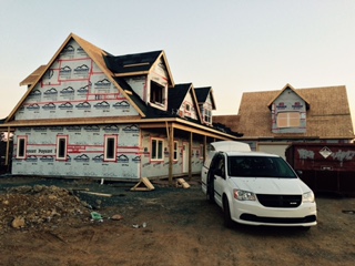 Van parked beside a house wrapped in building paper