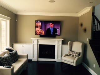 TV above a white fireplace mantel in a living room